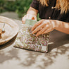 Woman putting phone back in kolkatta kitty clutch